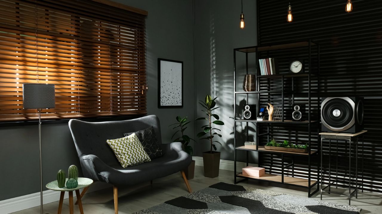 A modern living room with a gray sofa, black shelving, and wooden accents.