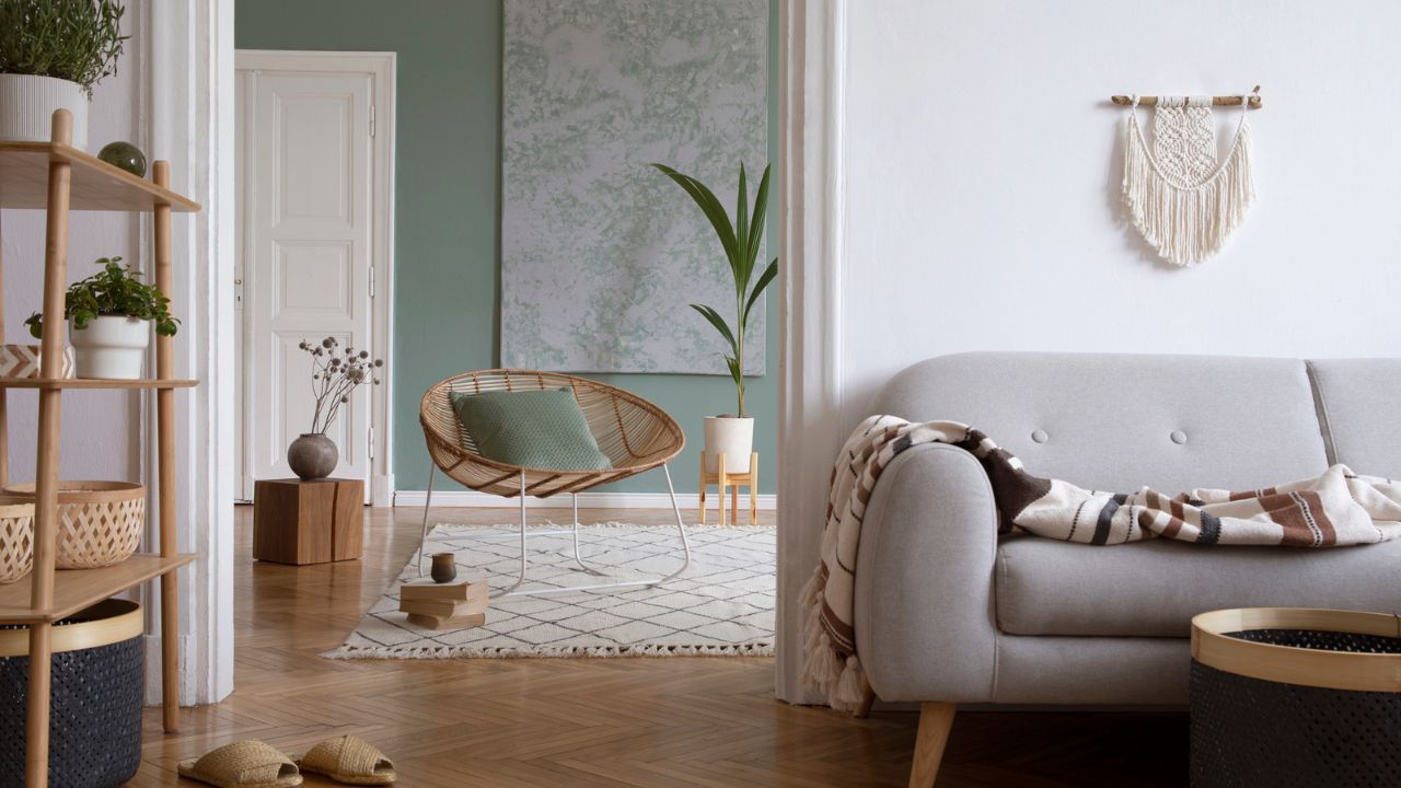 Cozy living room with green walls, white sofa, and wooden accents.