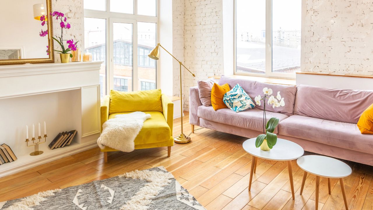 Bright and airy living space with large windows, flowers, and contemporary furniture.