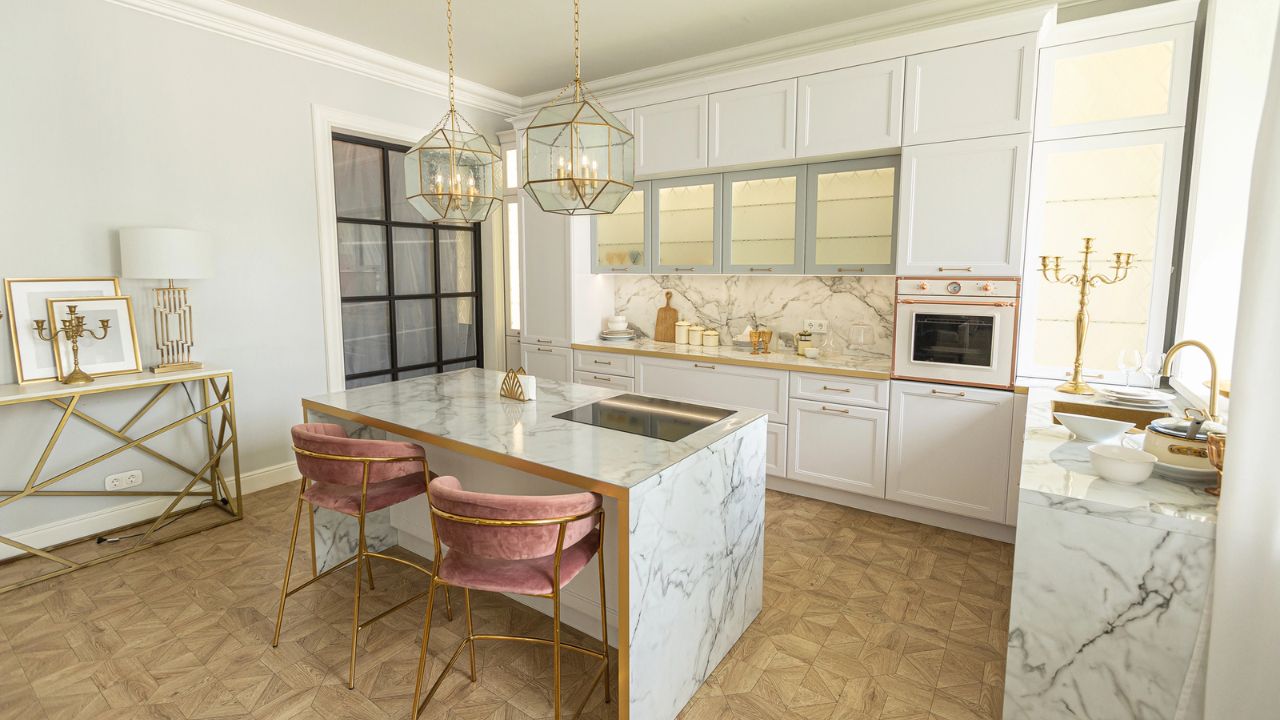 Modern kitchen with white cabinets, marble countertops, and pink accents.