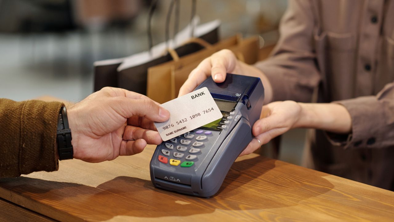 A person is paying with a card at a point-of-sale terminal.