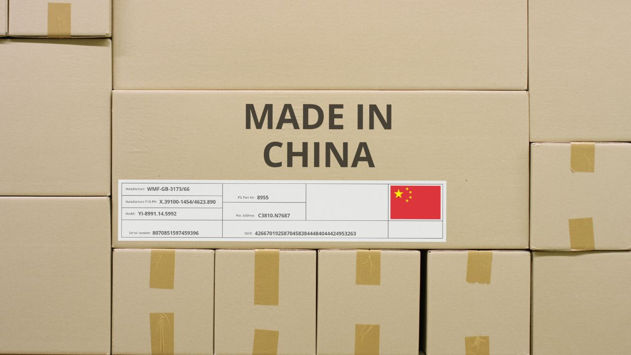 Stacked cardboard boxes labeled "Made in China" with a Chinese flag on a shelf.