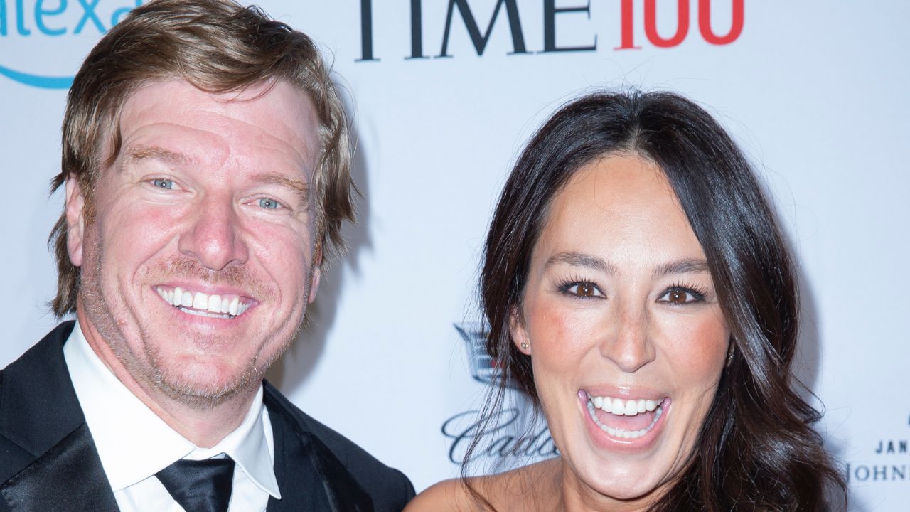 A man and woman smiling happily at a red carpet event.