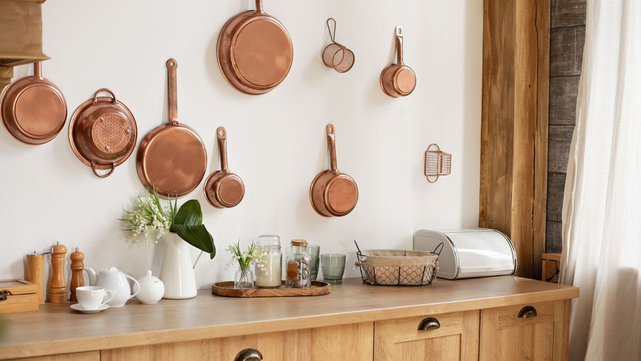 Kitchen scene with copper pots and wooden countertop.