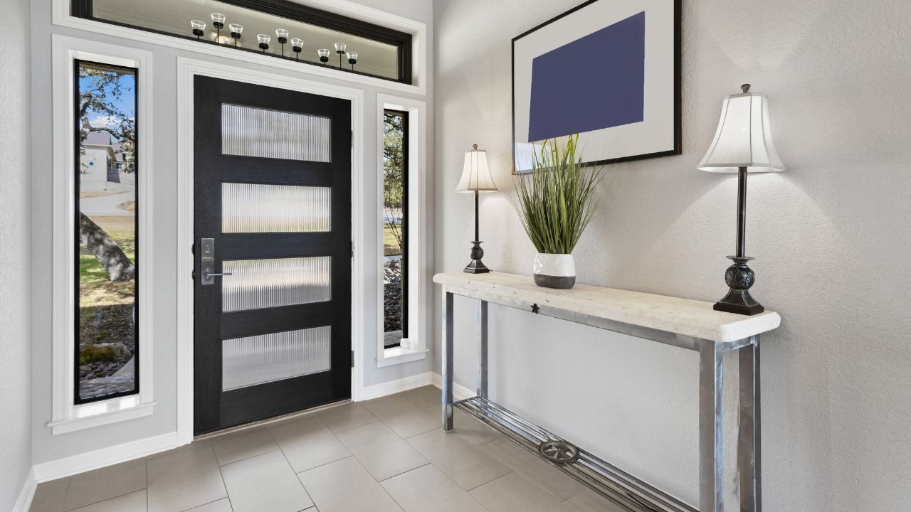 Entryway with a black front door, sidelight windows, and decorative lamps on a textured console table.
