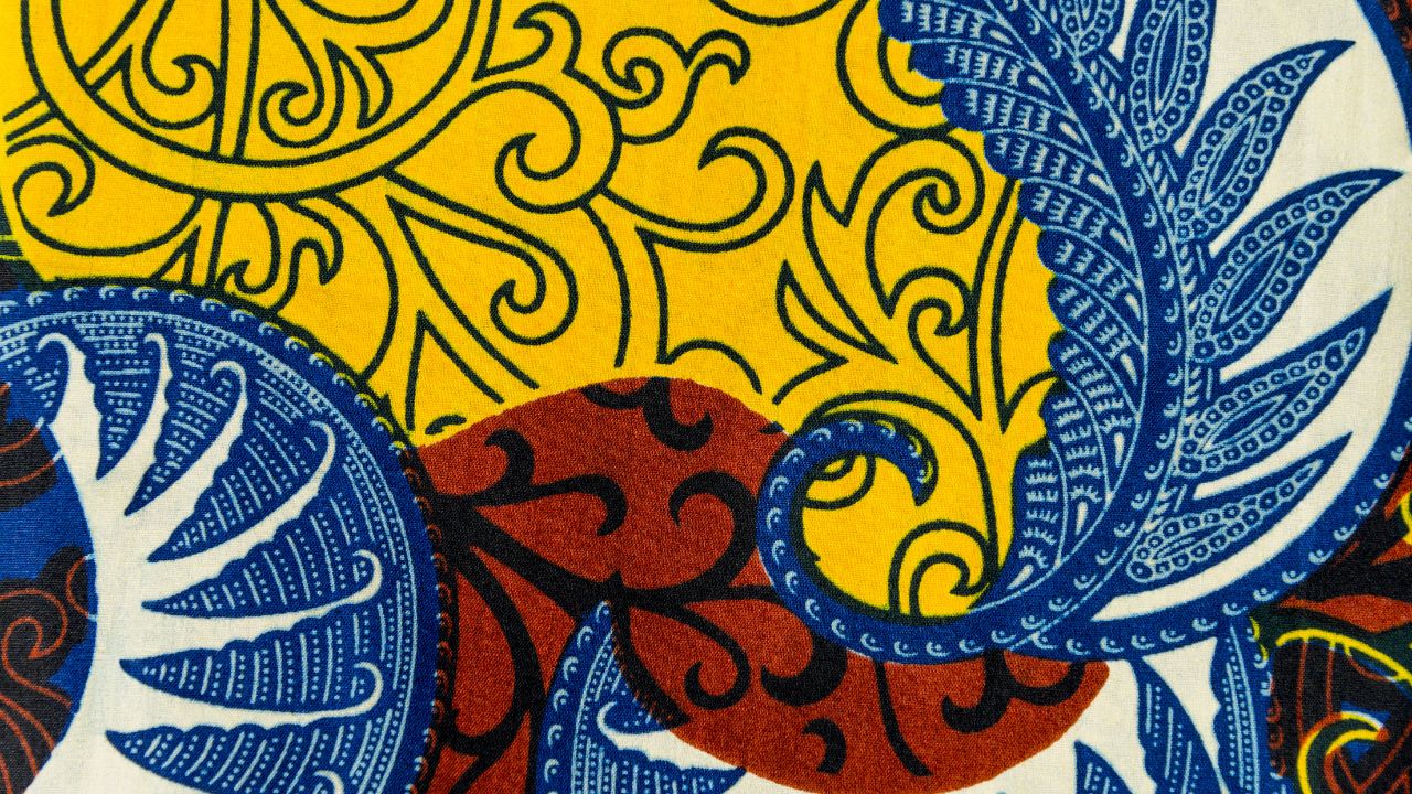 A vibrant, colorful fabric pattern that resembles traditional African textile designs.