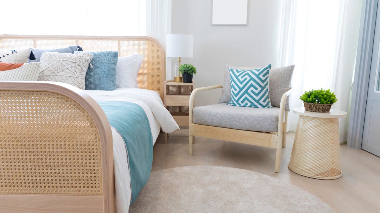 Light-filled bedroom with a white bed, blue accents, and numerous potted plants.