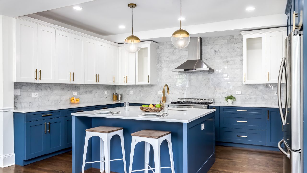 Bright modern kitchen with white cabinets, blue lower cabinets, and gold fixtures.