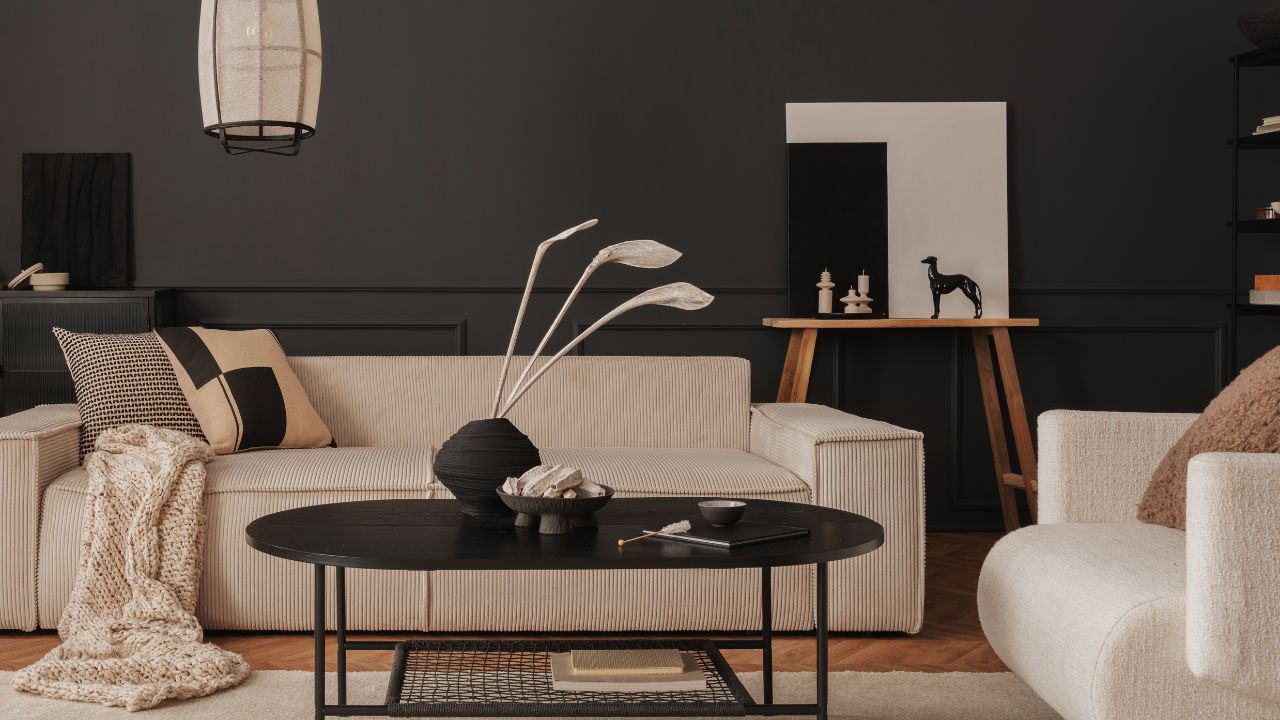 Modern living room with a beige striped sofa, black accents, and minimalist decor.