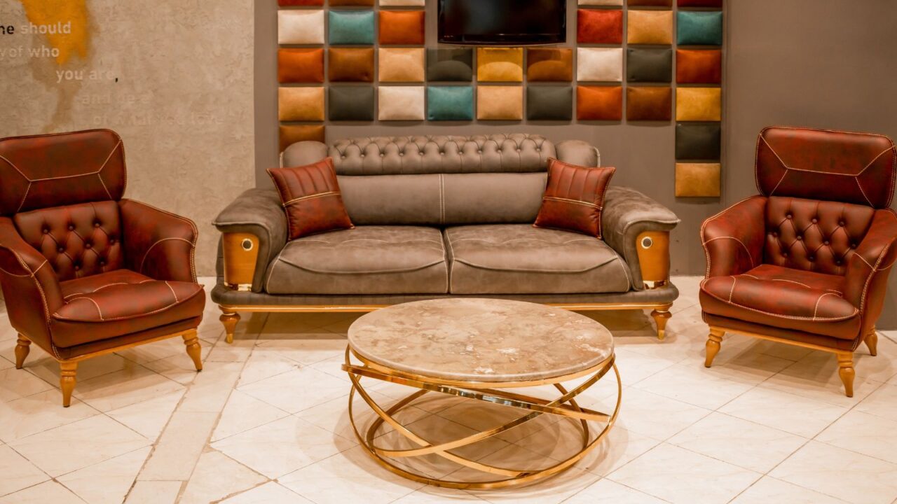 A stylish living room interior with leather sofa, wall paneling, and a coffee table with golden base and a marble top.