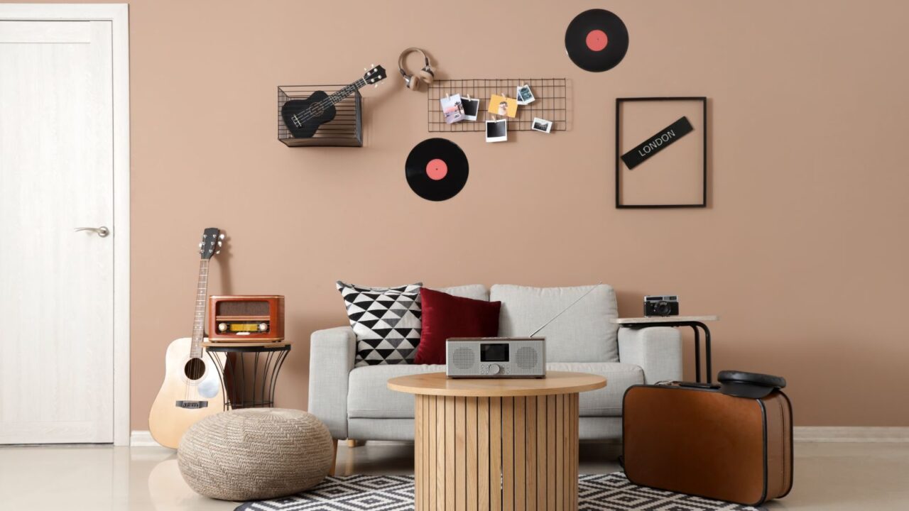 A room interior with sofa, guitar, coffee table, and a music wall.