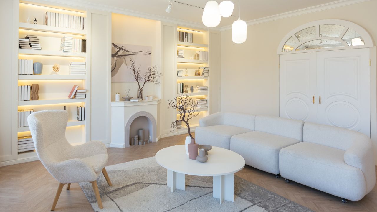Bright and cozy white living space with built-in bookshelves and a fireplace.
