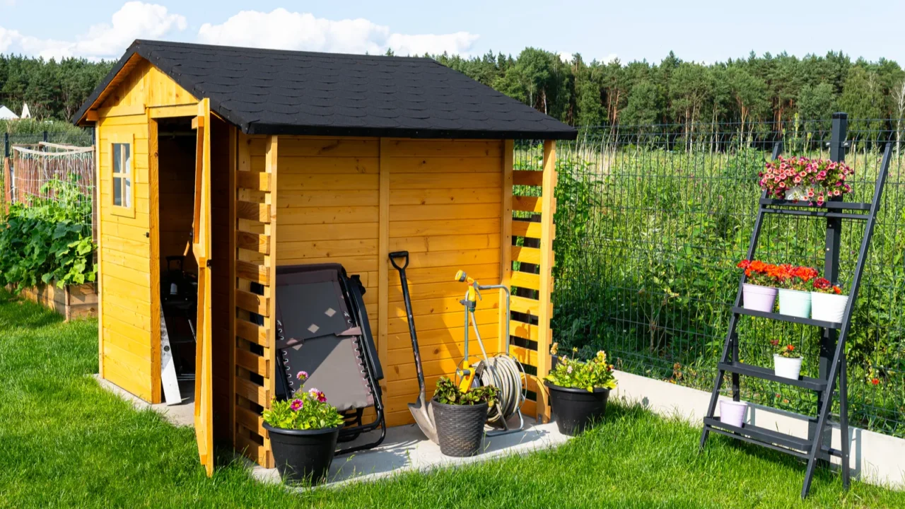 A wooden garden shed standing on a concrete foundation in