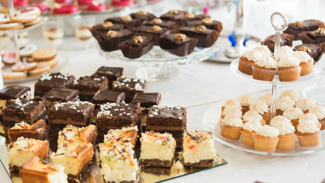 Baked sweet treats on a table arranged on flat and tiered trays.