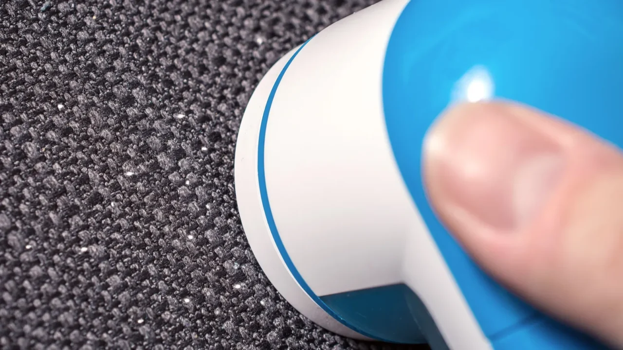 lint shaver removing the wool fuzz of a dark couch