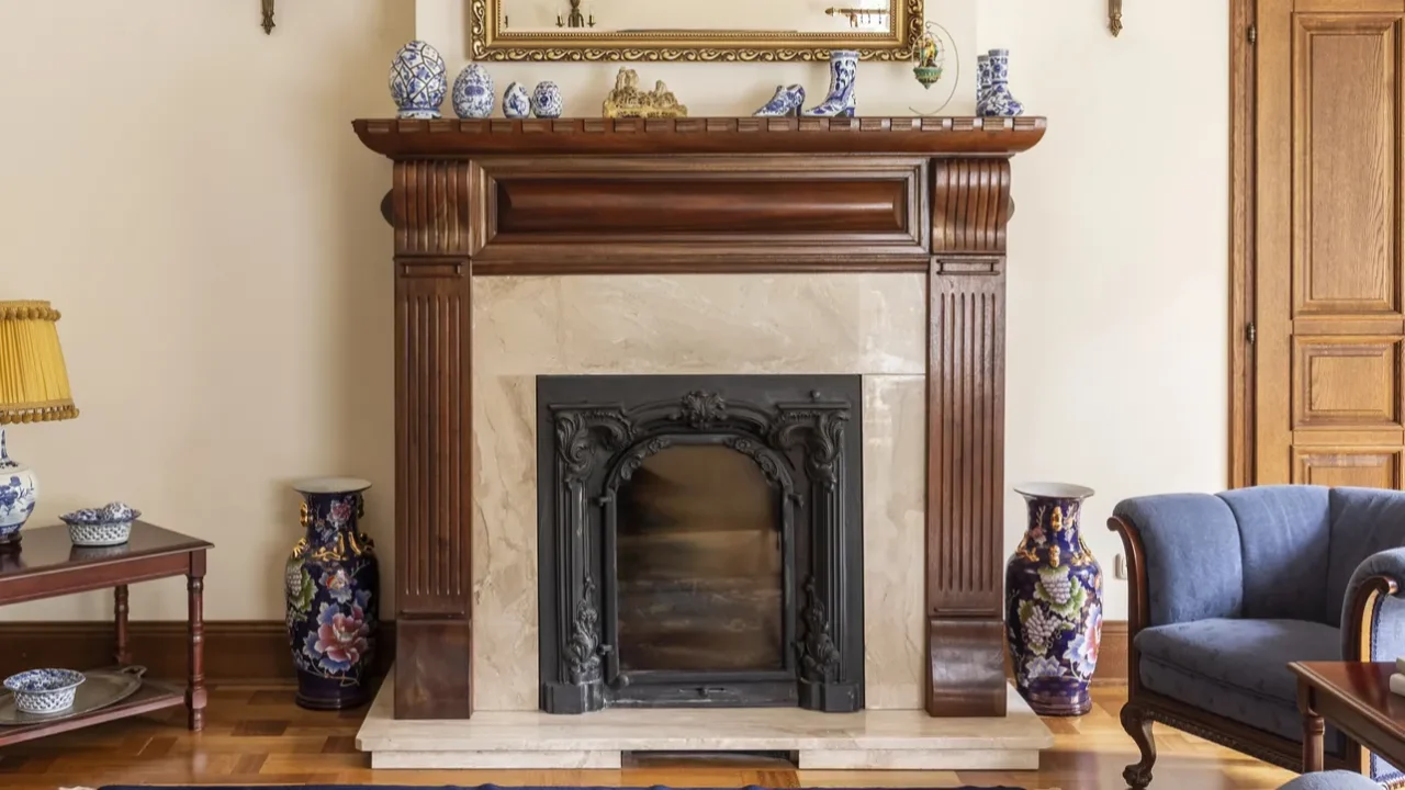mirror in gold frame above fireplace in sophisticated living room