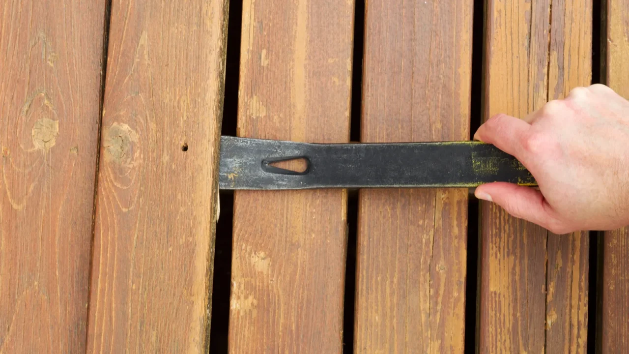 removing old wooden boards with pry bar
