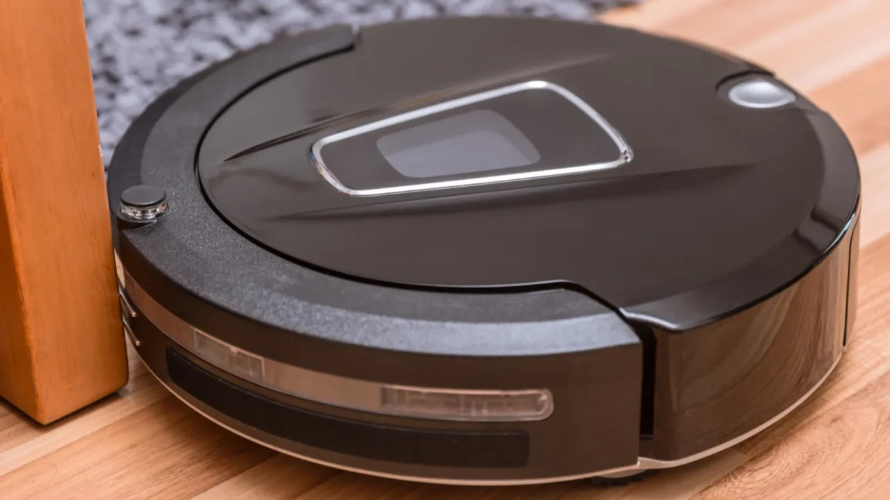 robot vacuum cleaner on laminate wood floor with carpet cleaning
