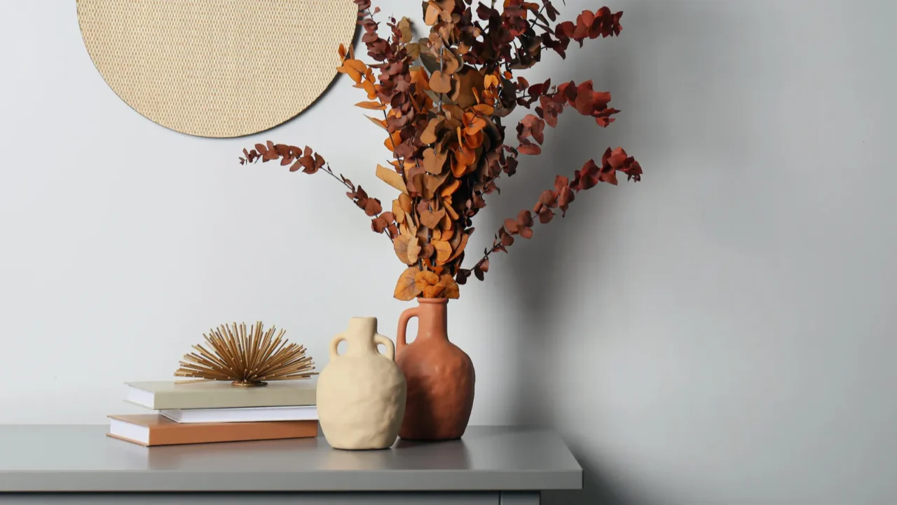 stylish vases dried eucalyptus branches and books on grey table