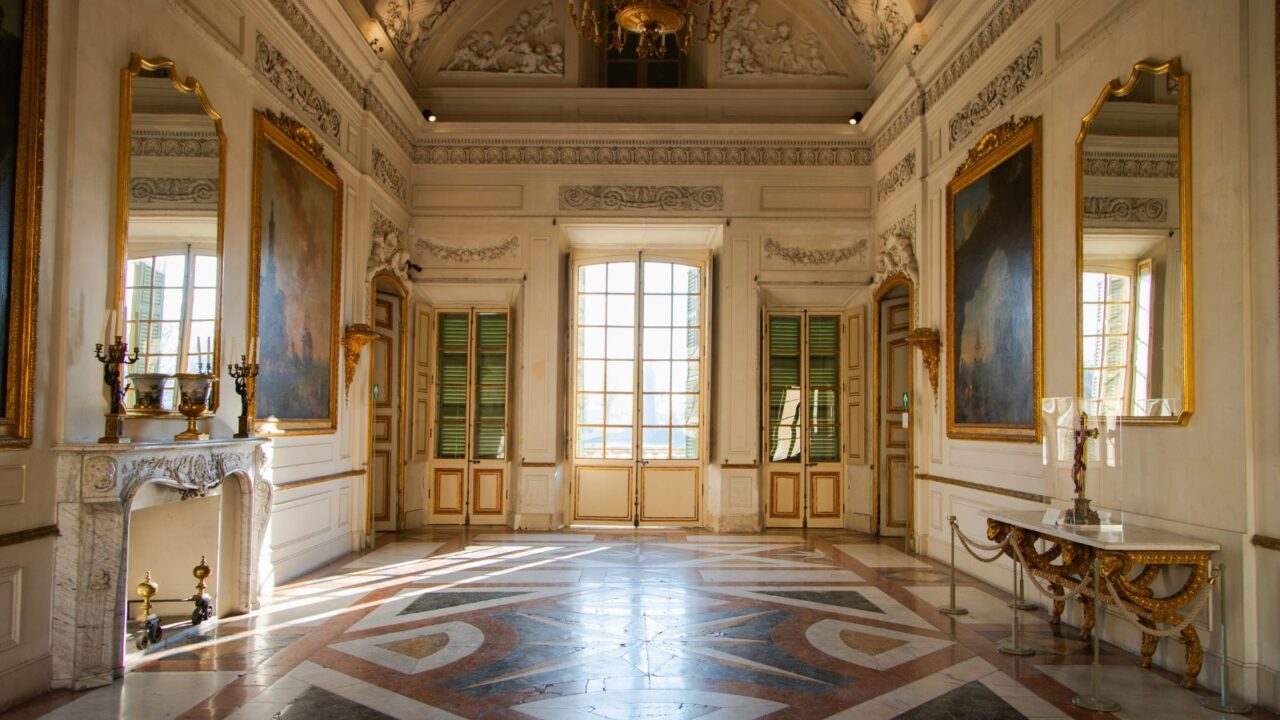 An elegant, classical interior room with large windows and ornate decor.