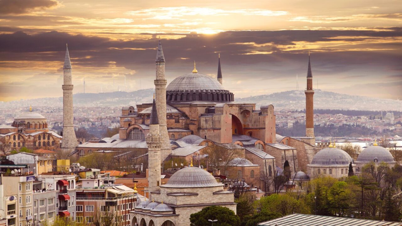 A historic mosque with multiple minarets at sunset.
