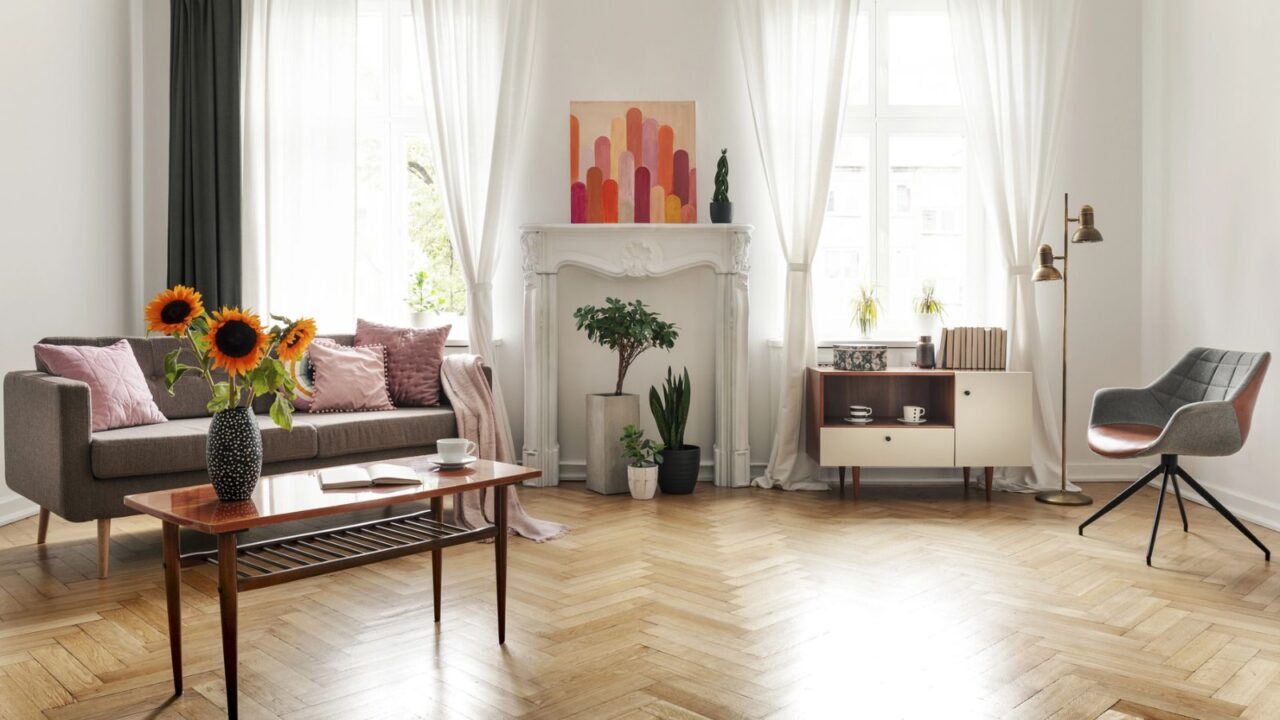 Cozy living room with white sofas, large windows, and modern decor.