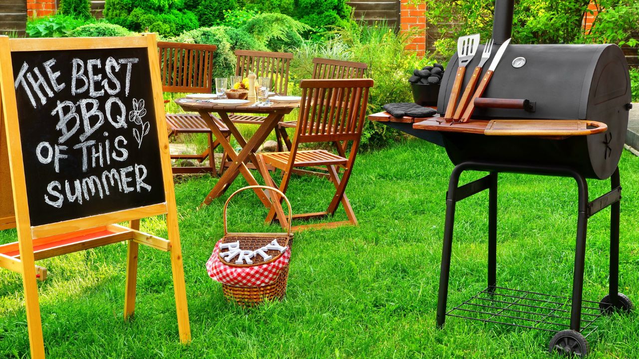 Outdoor BBQ setup with a chalkboard sign that says "The best BBQ of this summer."