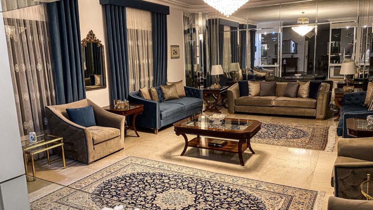 Elegant luxurious living room seating,mirrored walls,blue velvet drapes, Persian-style rugs,sparkling chandelier, sophisticated and ambiance with classical decor