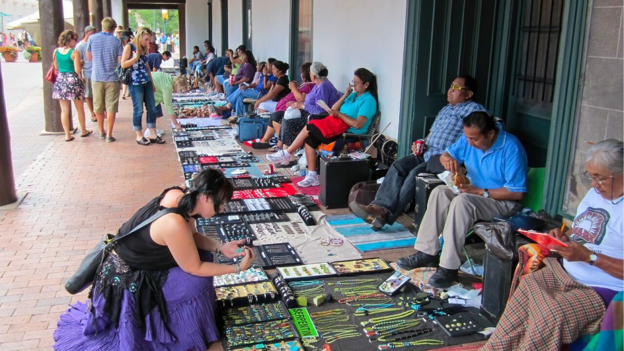 Santa Fe, NM / USA - Aug 13 2010: A woman examines Navajo jewelry for sale by native vendors under the historic Palace.