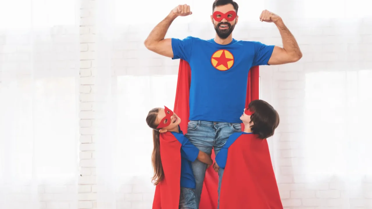 father with children in red and blue suits of superheroes