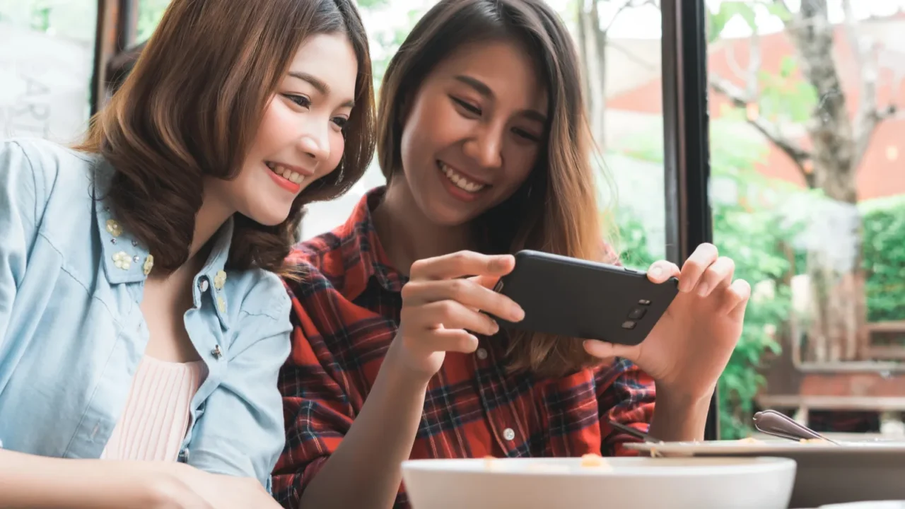 happy beautiful asian friends women blogger using smartphone photo and
