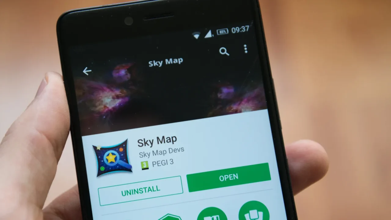 man hand holding smartphone with sky map application in google