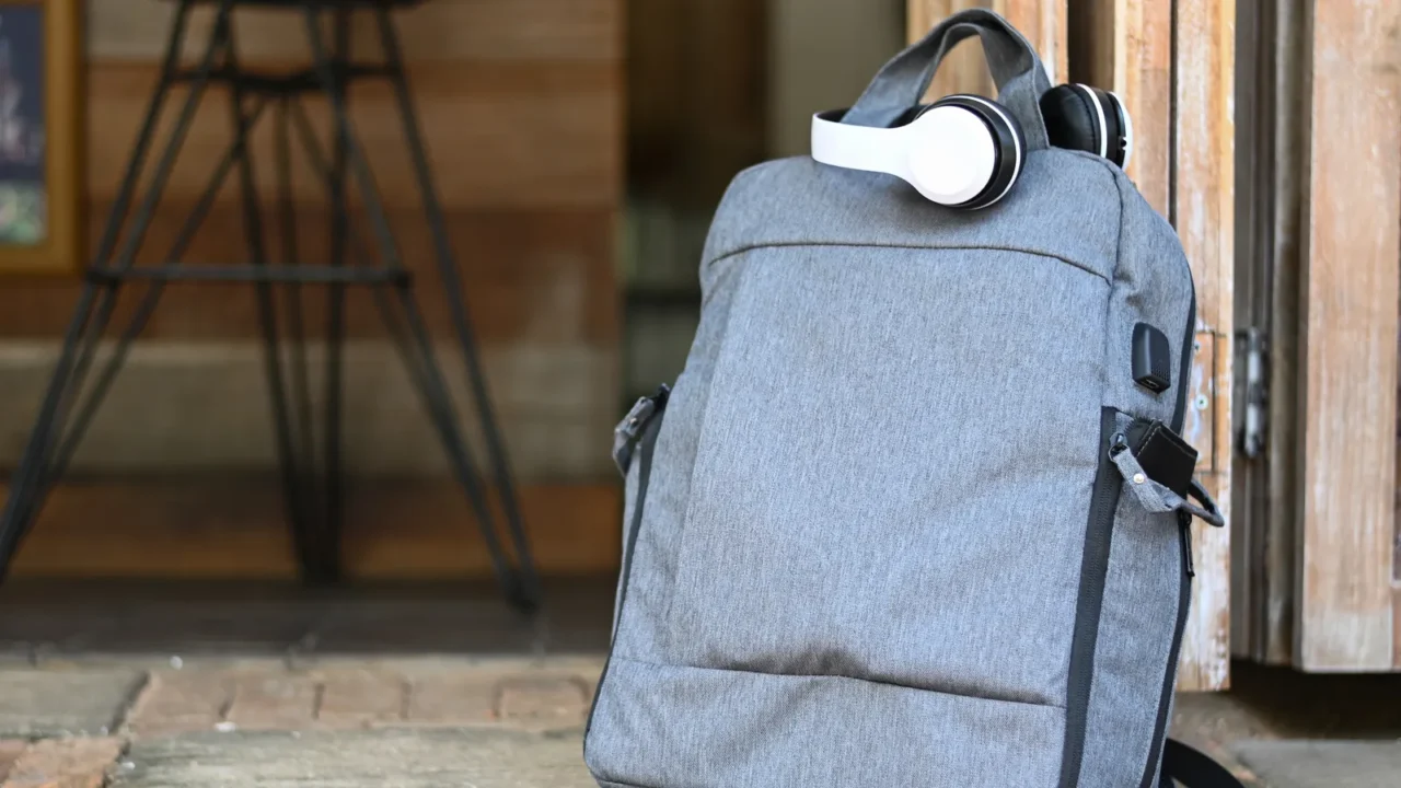 tourist backpack and headphones placed on the ground in front