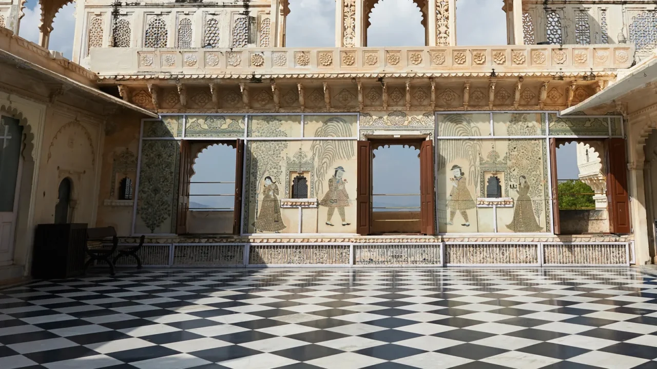 An elegant palace interior with a checkered black and white marble floor and arched windows with intricate detailing.