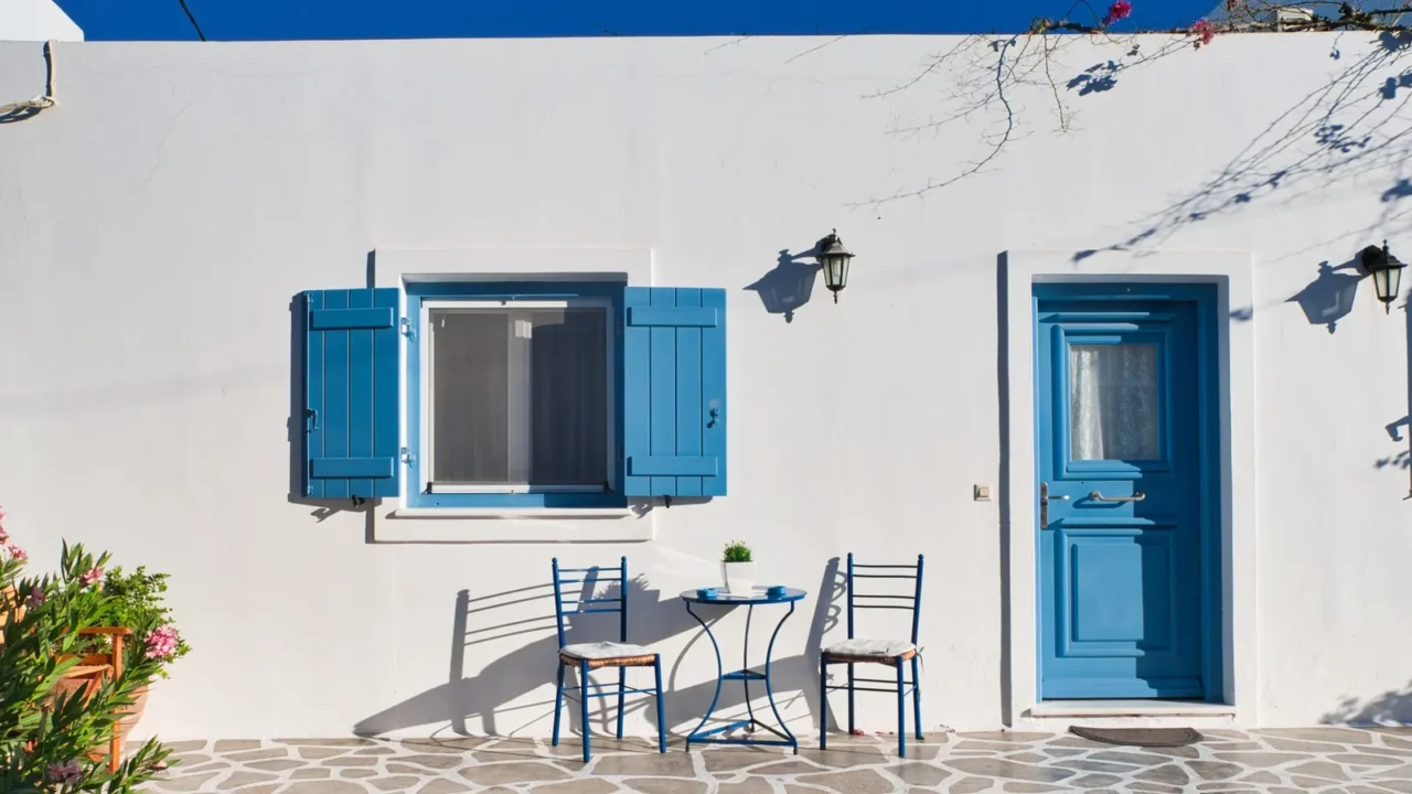 white building with blue door and open shutters