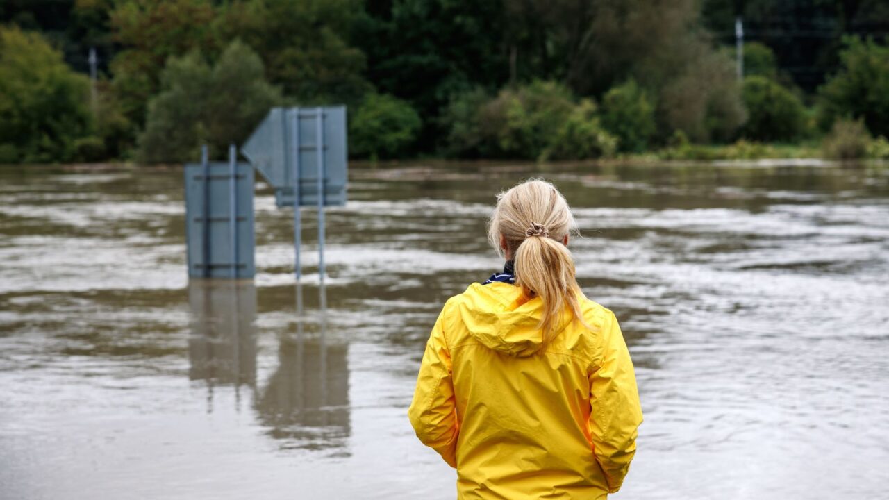 Worried woman looking at overflowing water during flood.