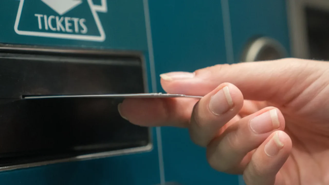 closeup hand with train ticket from self service machine