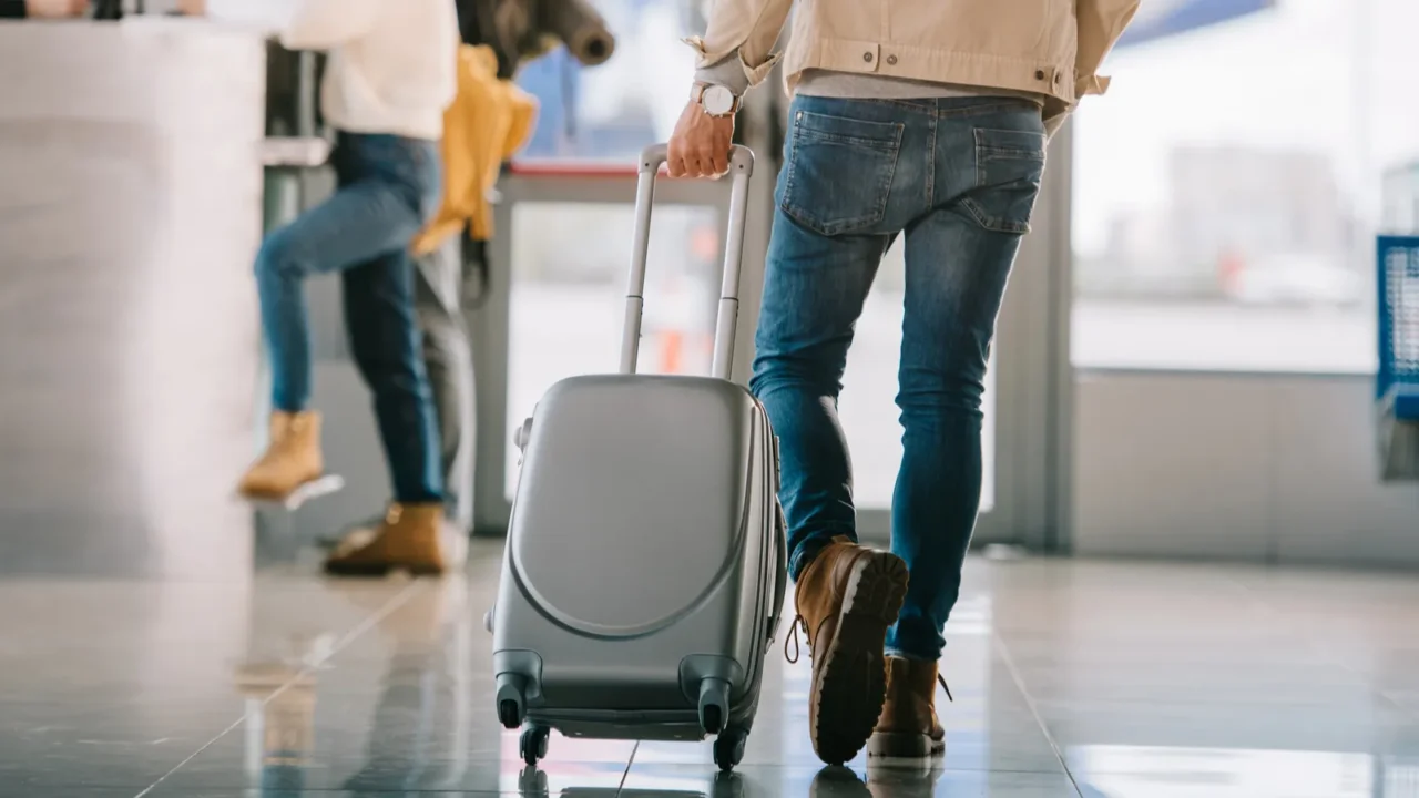 cropped shot of man with suitcase going to checkin desk