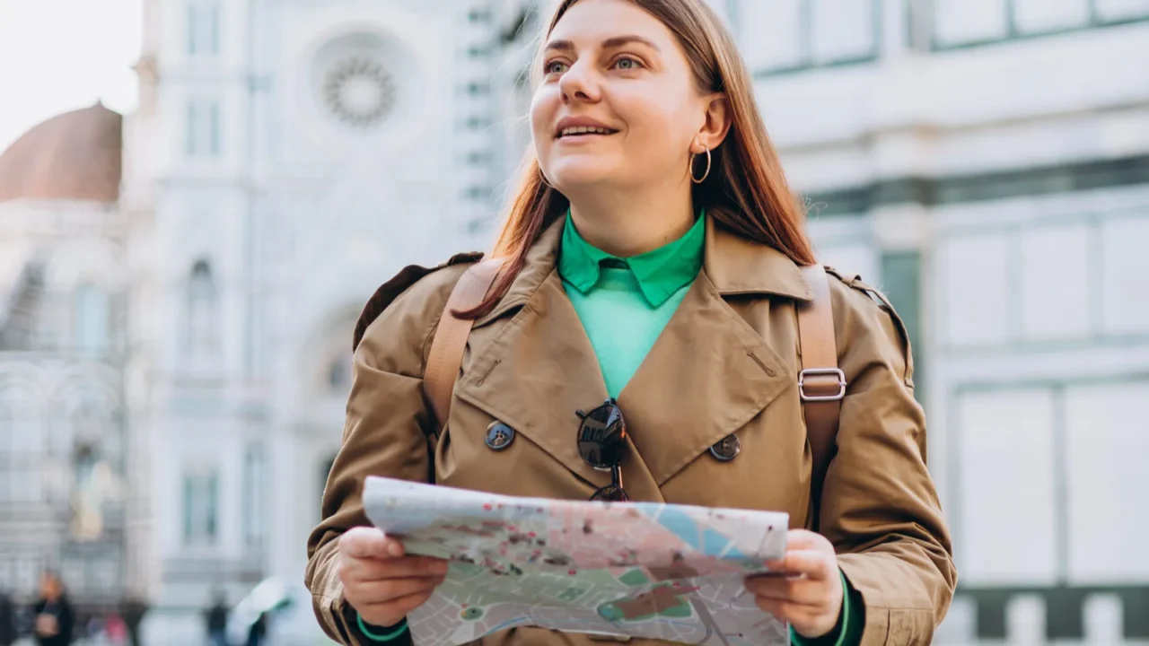 happy 30s young woman with map in old town in