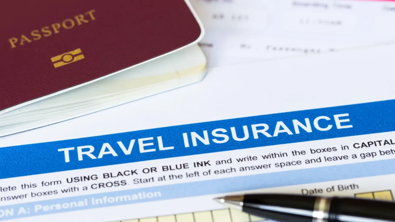 travel insurance application form with pen and passport
