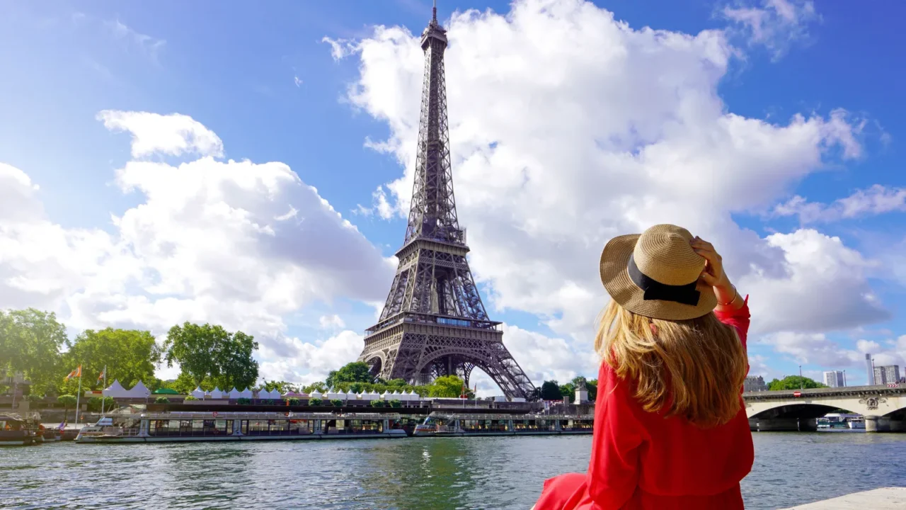 young traveler woman in red dress and hat sitting on
