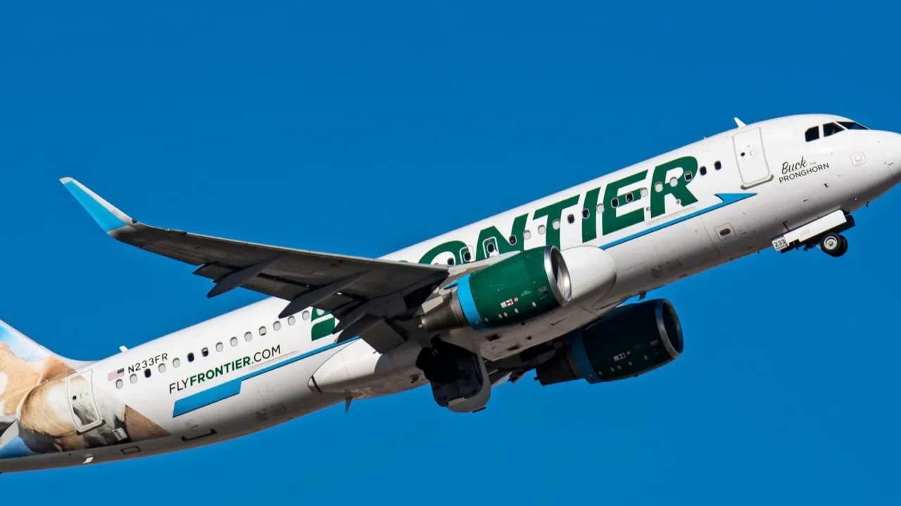 a frontier airlines a320 n233fr airplane flying in a blue