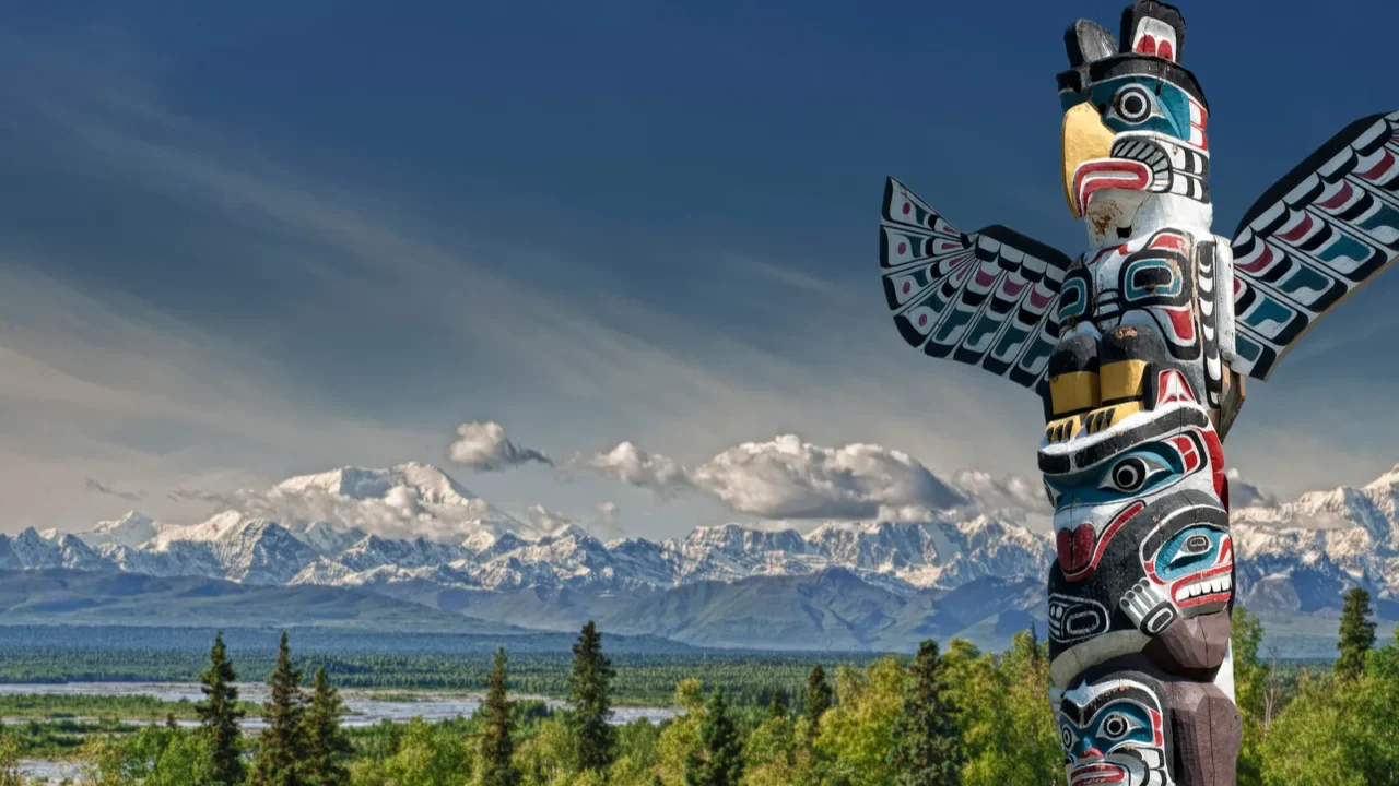 a totem wood pole in mountain background