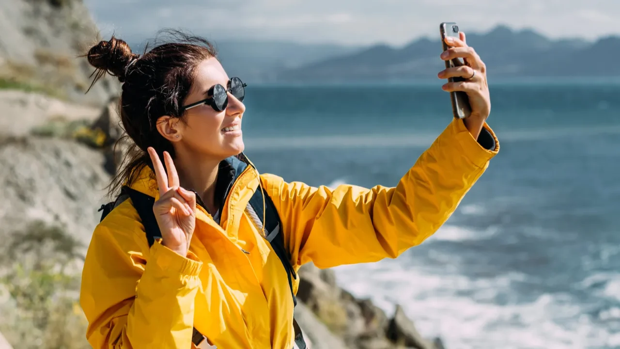 a traveler takes a selfie on her phone against the