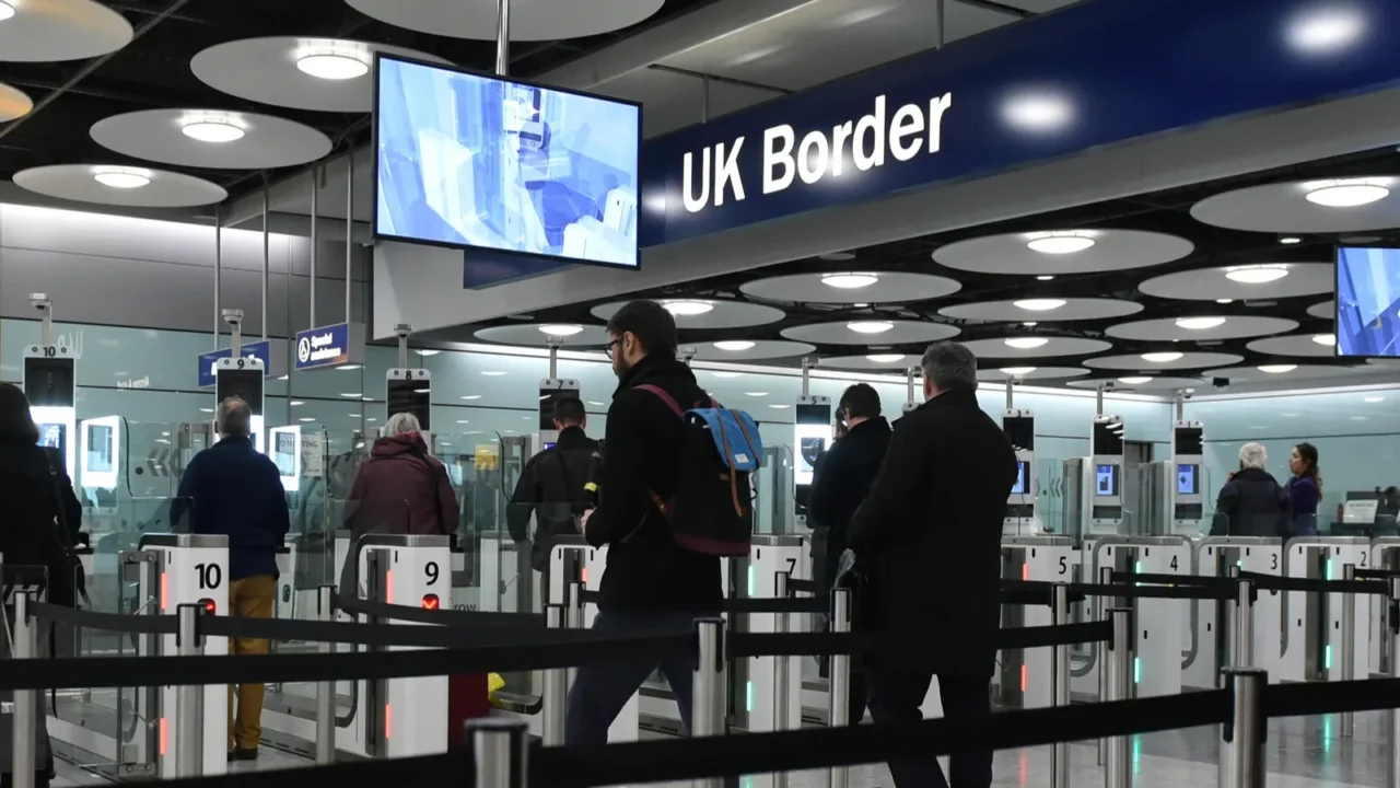 air travellers pass through customs channels at heathrow airport