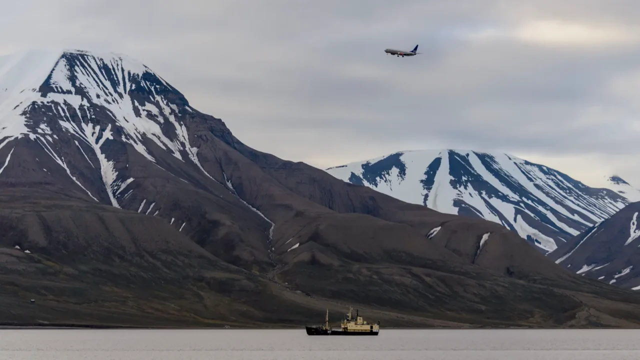 antarctic landscape with ship and plane over mountains