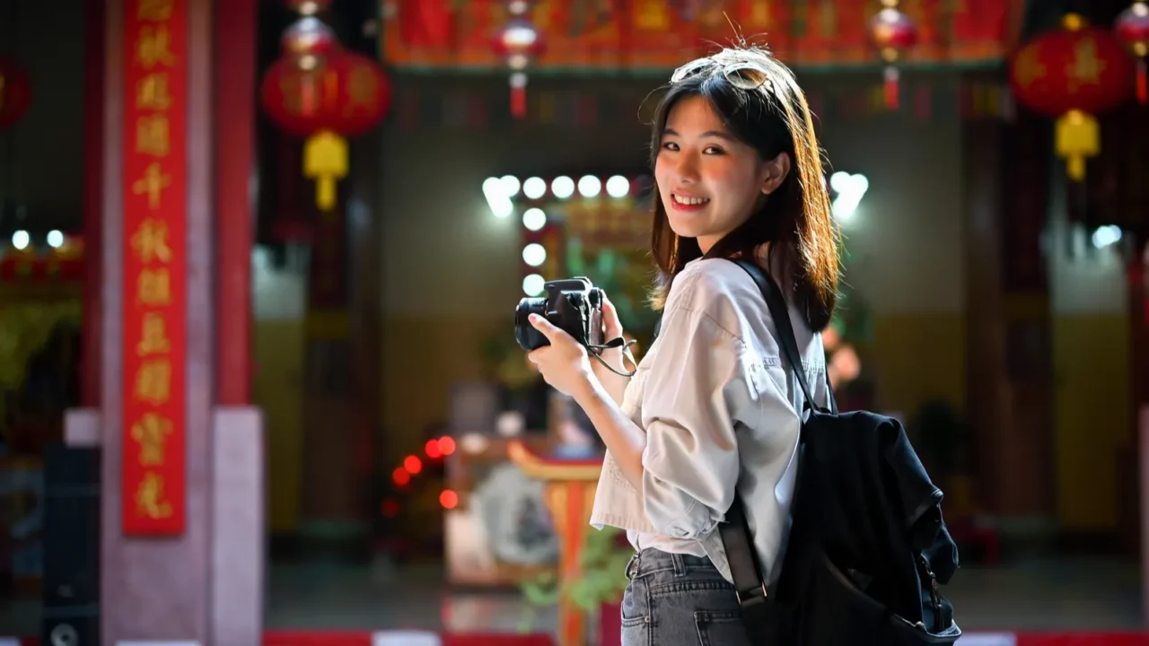 attractive and smiling young asian female tourist sightseeing and visiting