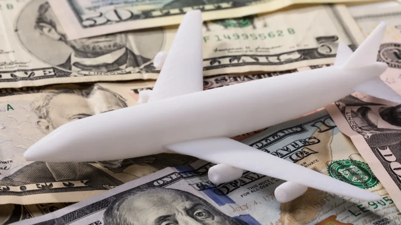 closeup of white airplane on dollar banknotes