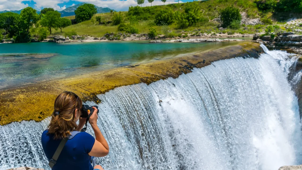 girl photographer takes pictures of niagara falls in montenegro