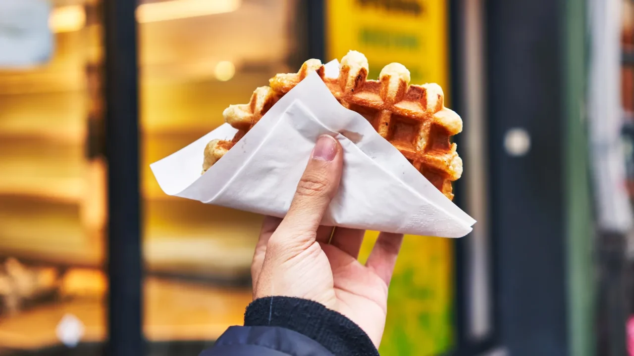 hand of man holding waffle at street